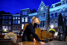 903800 Afbeelding van een serveerster van restaurant Graaf Floris (Vismarkt 13) te Utrecht die het terras opruimt, na ...